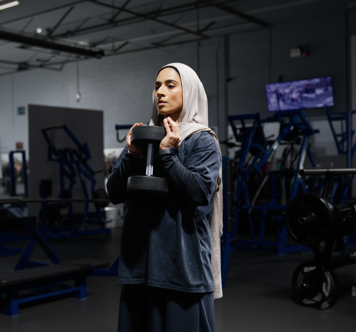 Woman lifting a dumbbell in a gym setting